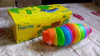 Simple studio shot of a rainbow plastic slug fidget toy against a clean white backdrop.