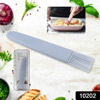 Silicone basting brush applying BBQ sauce to food on a grill.