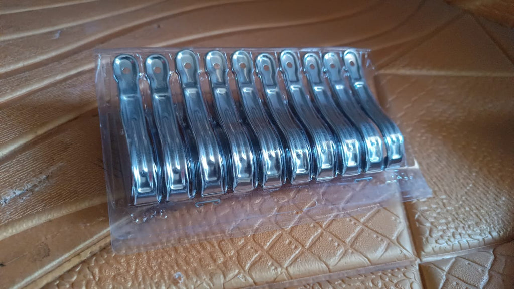 Multiple stainless steel clothespins clipped on clothesline with strong grip.