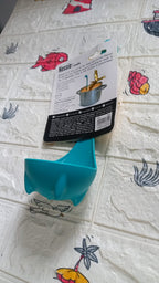 Multifunctional silicone soup spoon being used to strain vegetables from a pot.