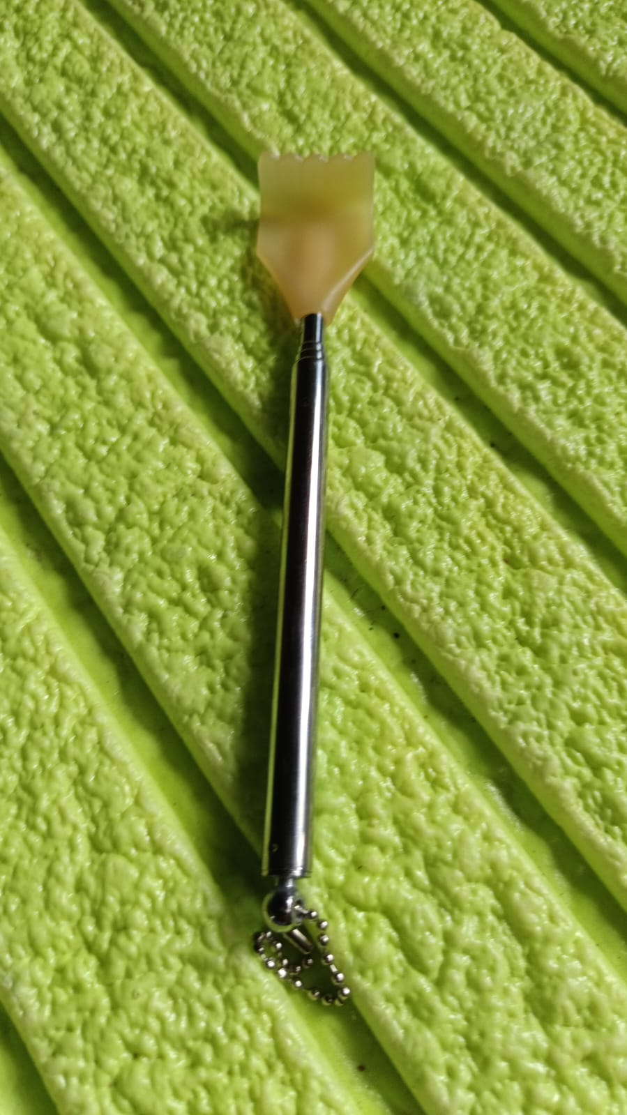 The compact back scratcher displayed neatly in its product packaging.