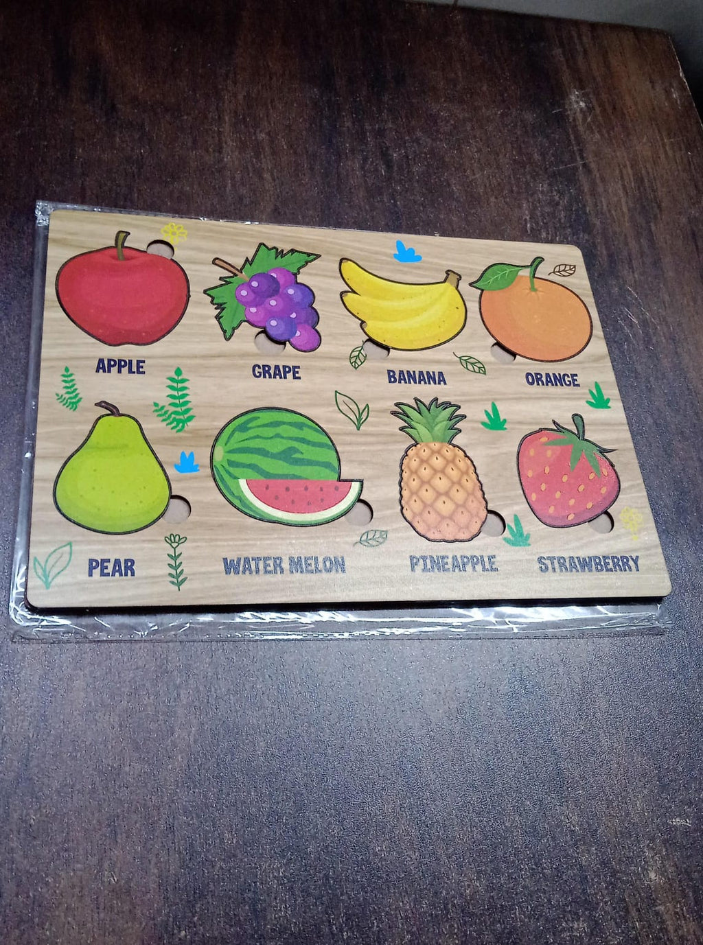 Lifestyle shot showing the wooden fruit puzzle in a child's play area.