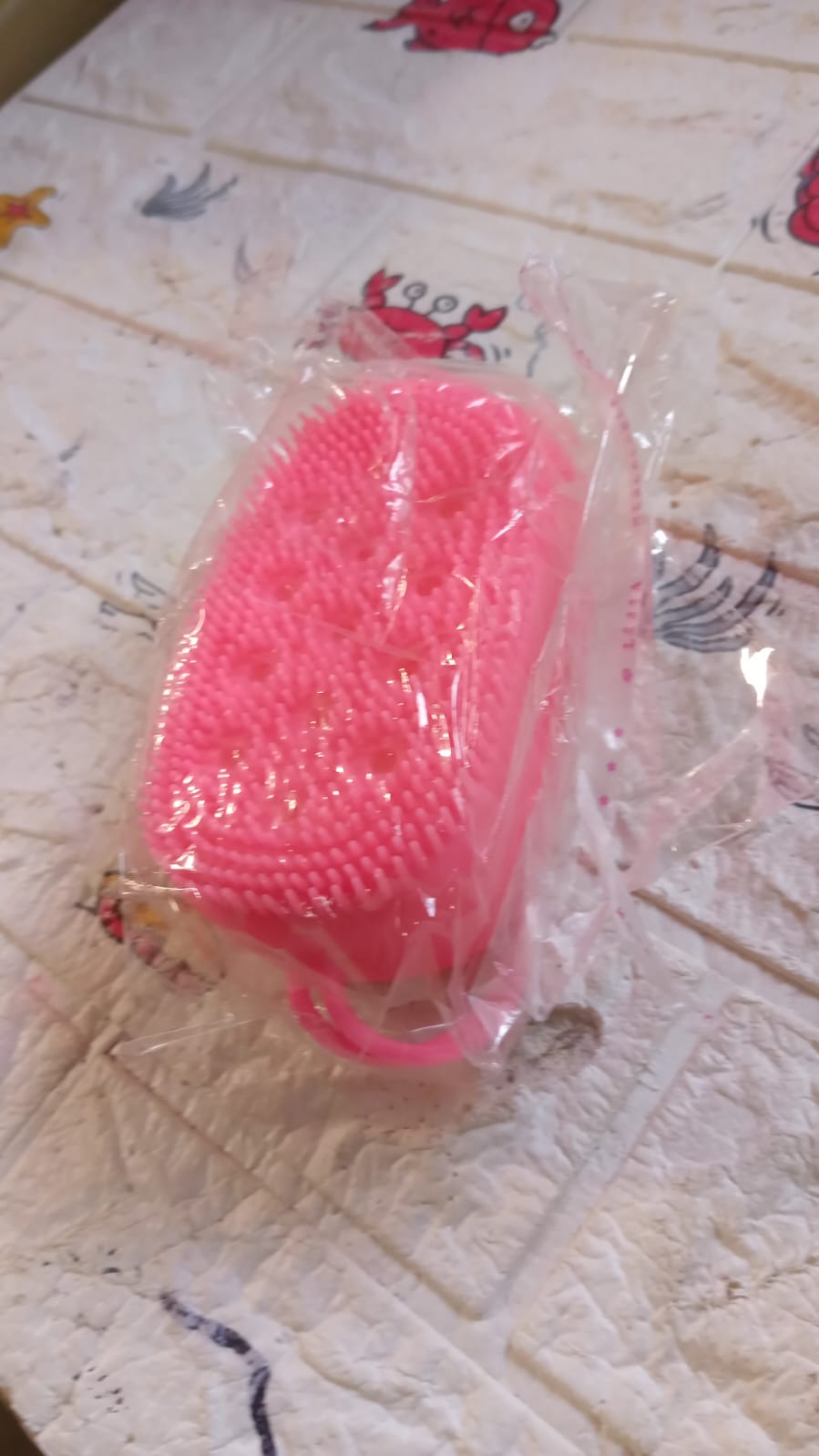 Flexible silicone body brush displaying its two distinct textures for comprehensive care.