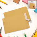 Brown Kraft Envelopes, 16x14 inches, stacked neatly on a wooden surface.