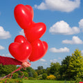 Set of four vibrant heart shaped balloons for party decorations.