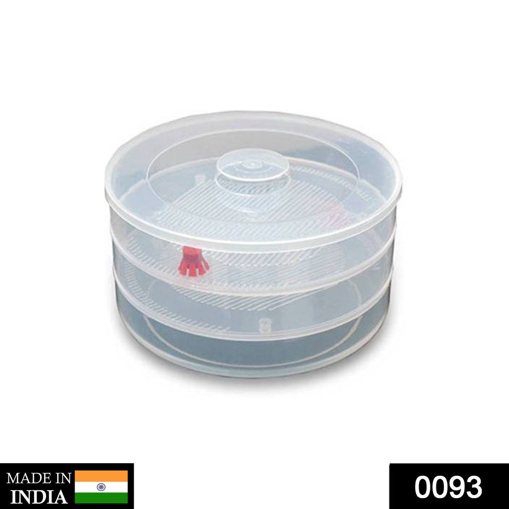Side view of a white plastic 3 compartment sprout maker on a kitchen counter.