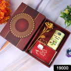 Valentine’s Day gift box with heart-shaped light, chocolates, and golden flower