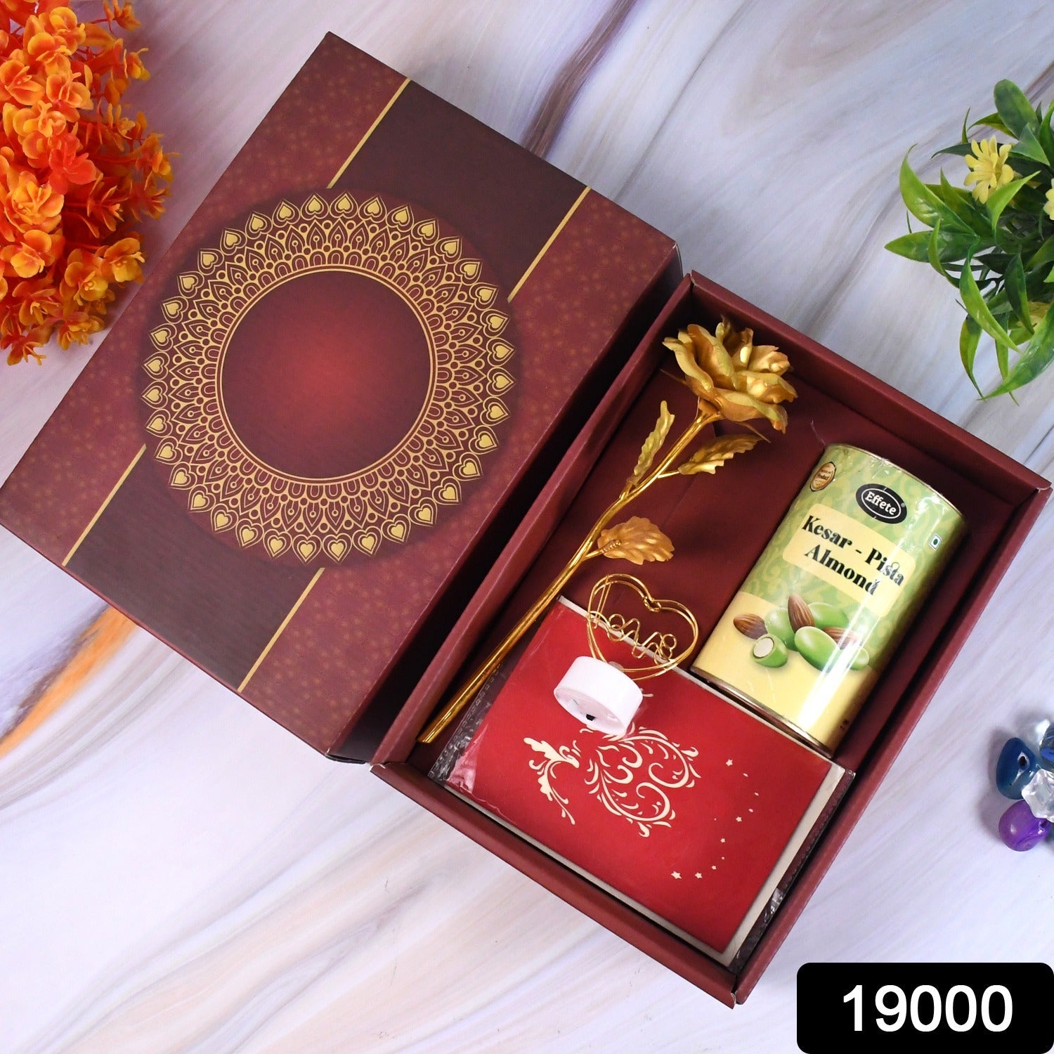 Valentine’s Day gift box with heart-shaped light, chocolates, and golden flower