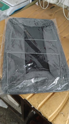 Foldable cloth storage organizer bag placed beside wardrobe