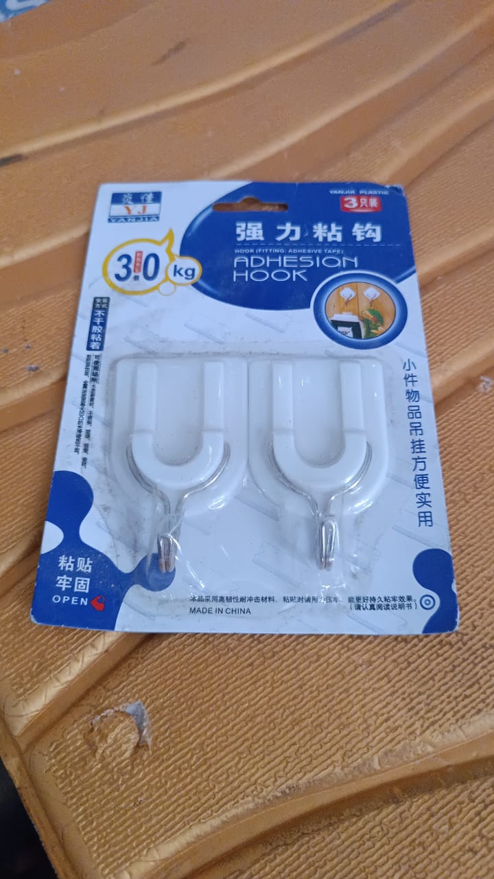 Multiple stainless steel adhesive hooks arranged on a wall, ready for various items.