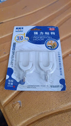 Multiple stainless steel adhesive hooks arranged on a wall, ready for various items.