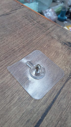 Simple wall hook with a clear adhesive base, ready for quick installation.