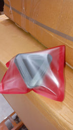 Compact pyramid mobile phone stand placed on desk showing size