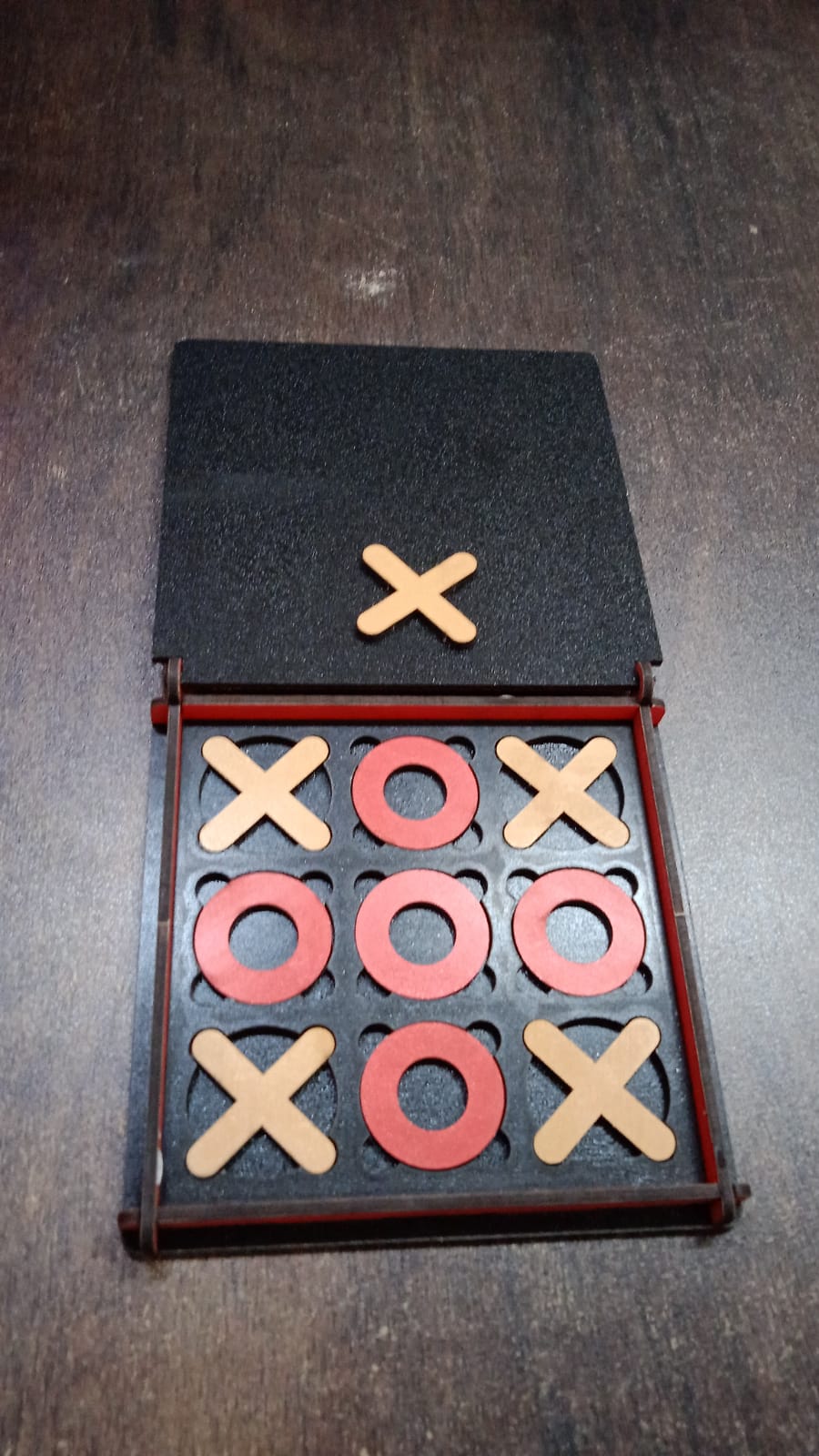 Lifestyle image of the X & Zero wooden board game, ready for play on a table, suggesting family fun.