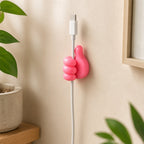 Pink and yellow thumb wire holders holding USB cable on wall lifestyle