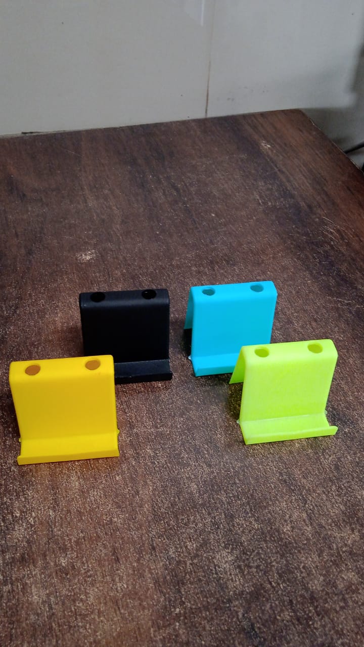 Mixed color mobile phone stand and pen holder placed on wooden table