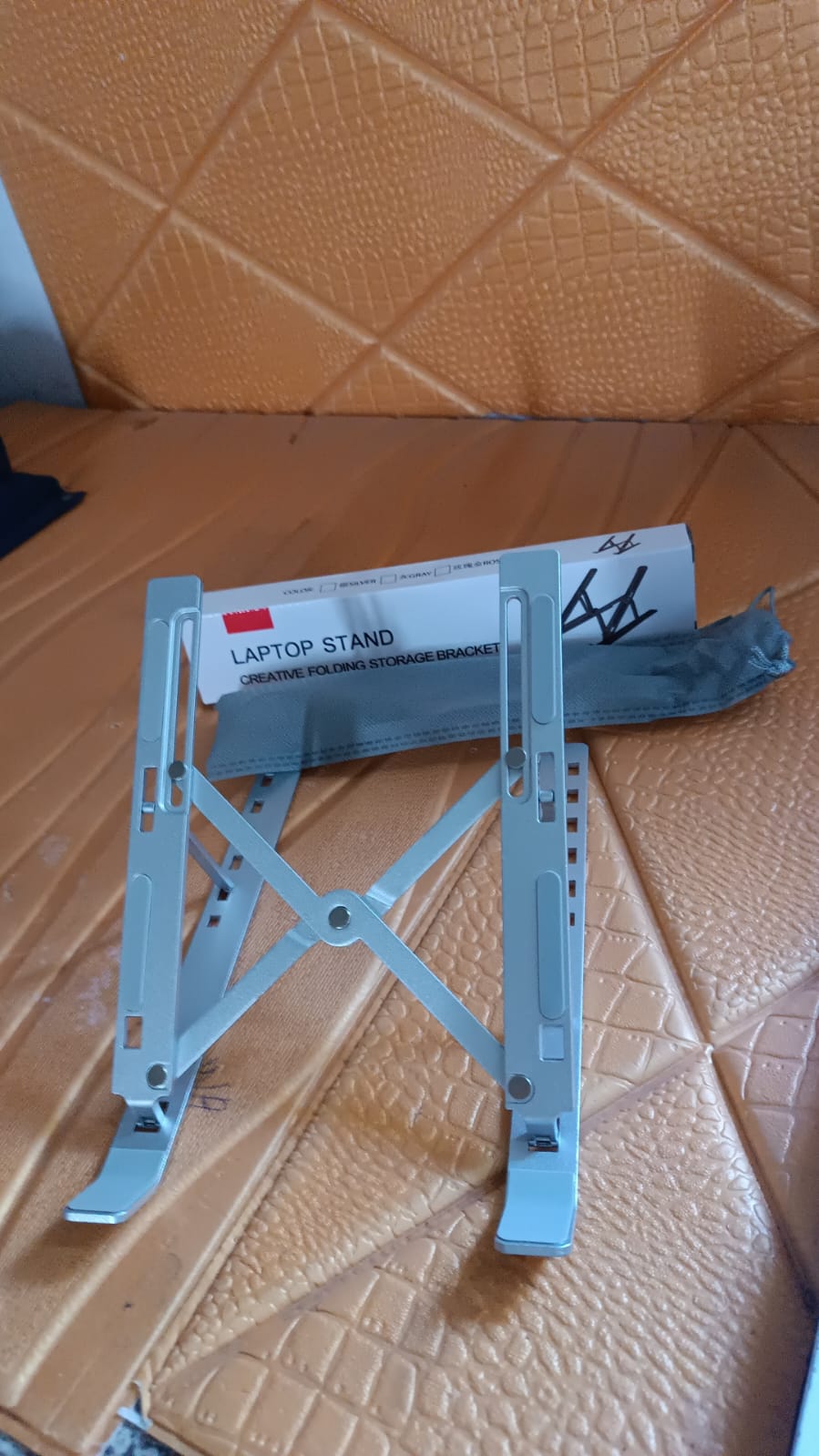 Laptop stand angled to ergonomic height to reduce neck and wrist strain