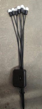 Solar powered garden light with glowing fiber optic strands in green lawn