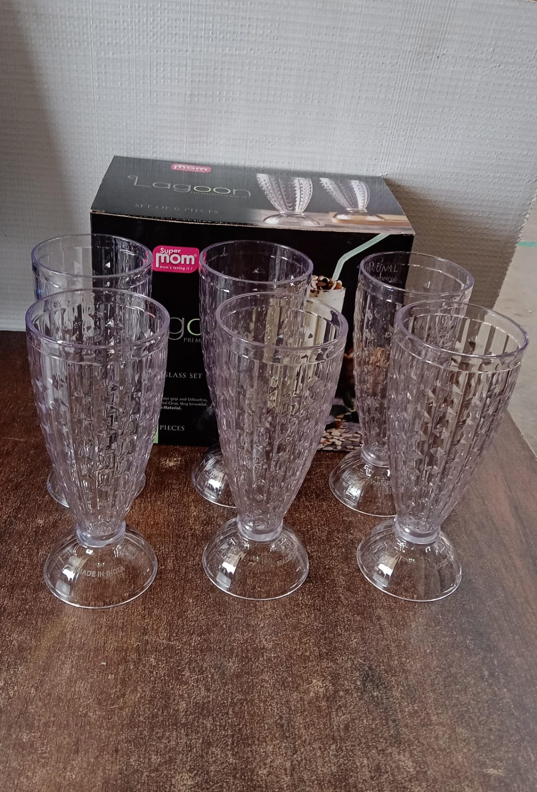 Full set of six Supermom transparent plastic milkshake glasses displayed together