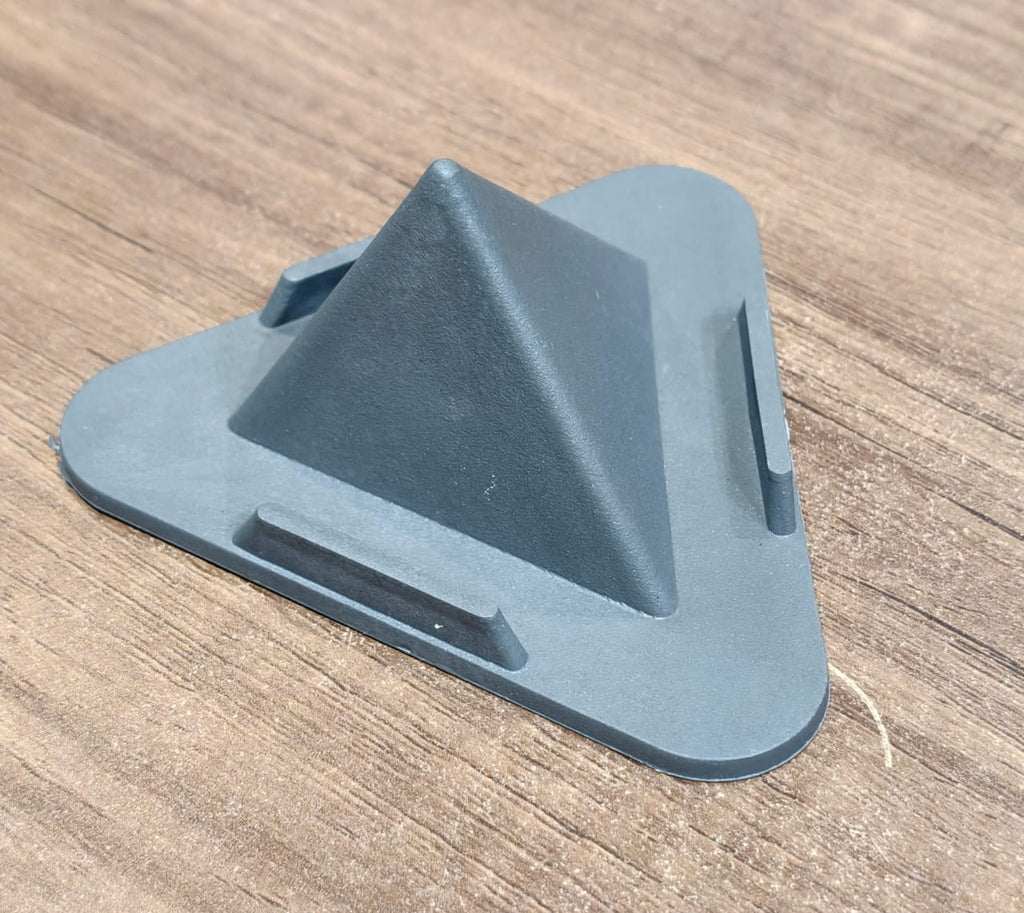 Grey pyramid mobile phone stand placed on office desk