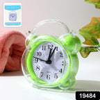 Compact quartz analog alarm clock with green transparent frame on desk