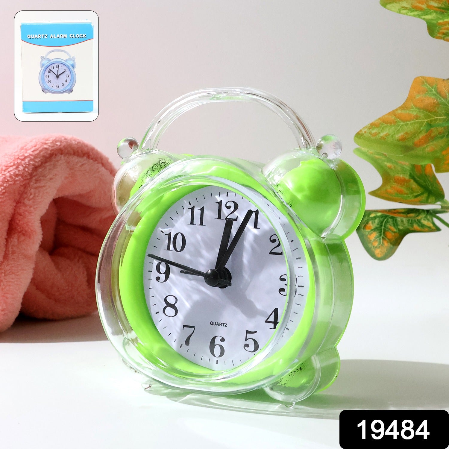 Compact quartz analog alarm clock with green transparent frame on desk