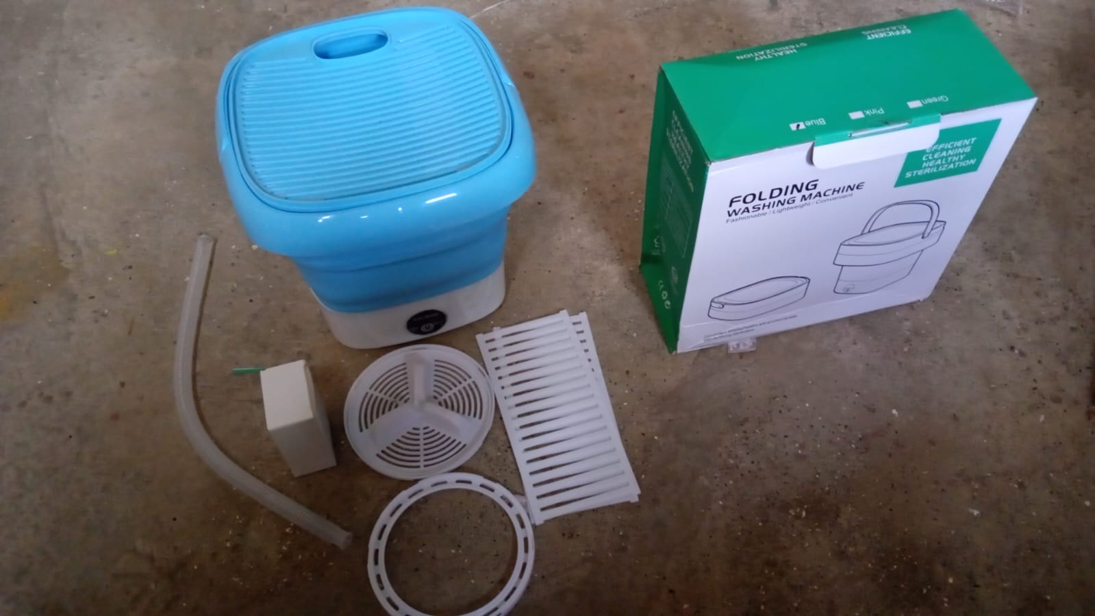 Lifestyle shot of the mini washing machine being used in a small apartment or dorm room.