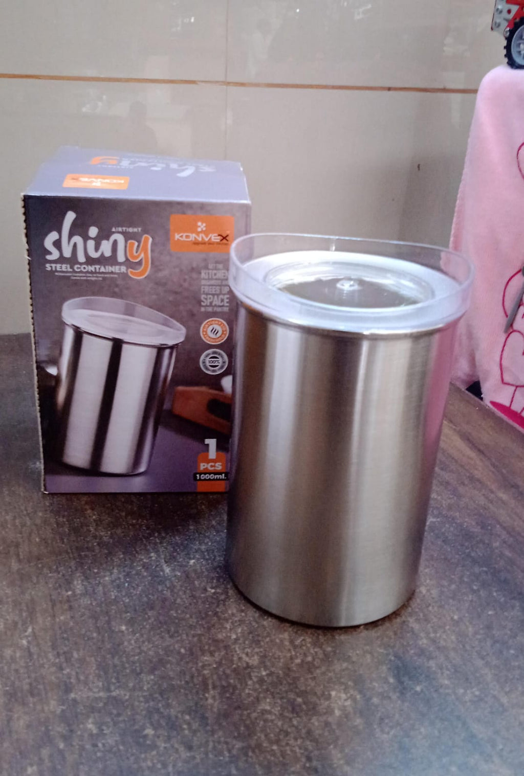 Konvex steel container filled with vibrant spices, highlighting its see-through lid.
