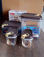 Set of four clear airtight food containers on a kitchen counter.