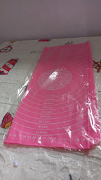 Hands rolling dough on the silicone baking mat, utilizing its non-stick property and guides.