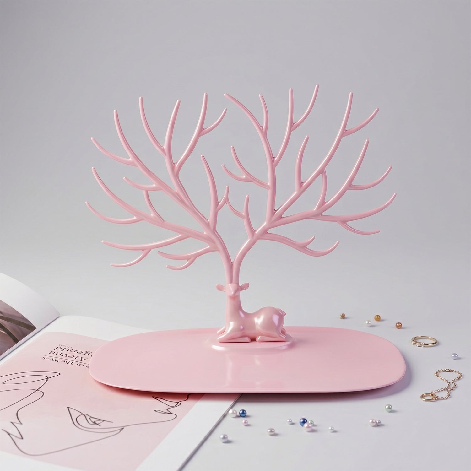 Front view of pink deer jewelry stand with earrings and rings, India