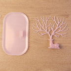 Pink deer jewelry stand with earrings displayed, India
