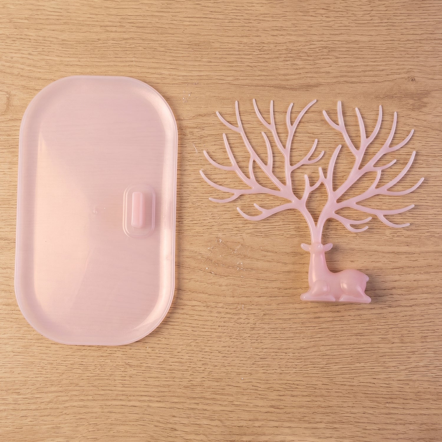 Pink deer jewelry stand with earrings displayed, India