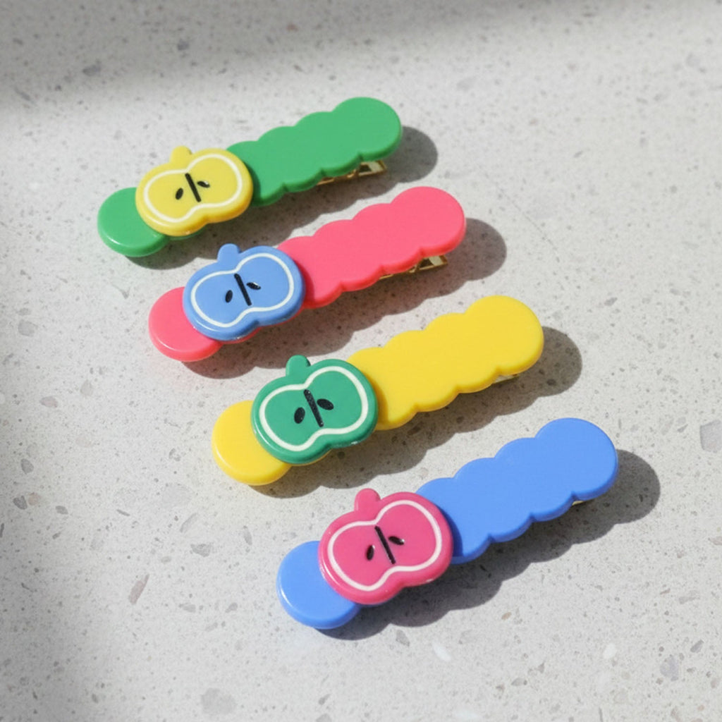 Four apple hair clips arranged to show design and color variety