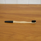 Lifestyle shot of bamboo charcoal toothbrush in use