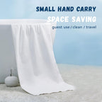 Compressed travel bath towel in expanded form lying flat