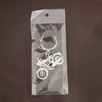 Lifestyle shot of a motorcycle silhouette metal keychain attached to a set of keys.
