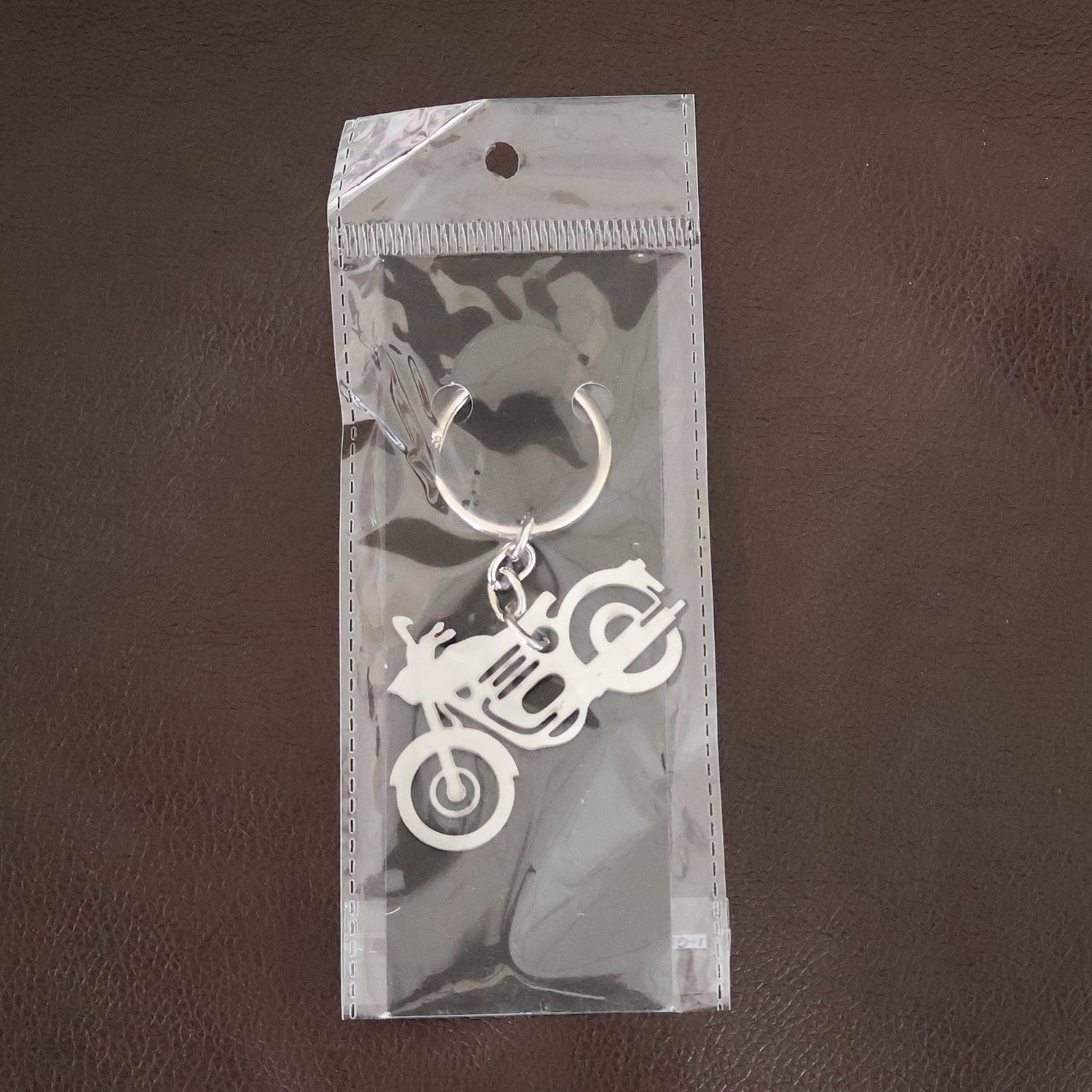 Lifestyle shot of a motorcycle silhouette metal keychain attached to a set of keys.