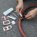 Components of bicycle tire repair kit including adhesive patches, glue tube, and metal file
