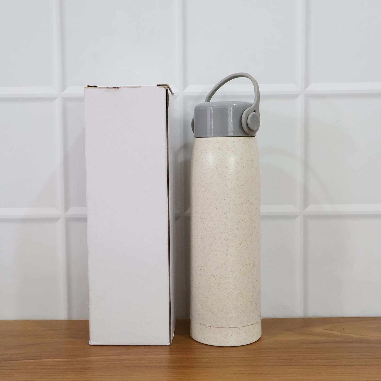 Lifestyle shot featuring the glass water bottle with phone holder in a natural setting.
