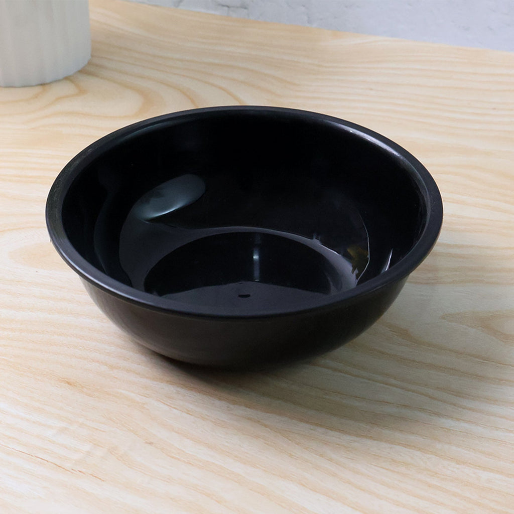 Black round plastic serving bowl on white background