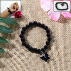 Elegant beaded bracelet with butterfly charm worn on wrist