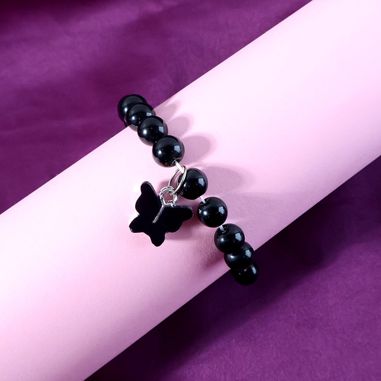 Butterfly charm and elastic band details of beaded bracelet