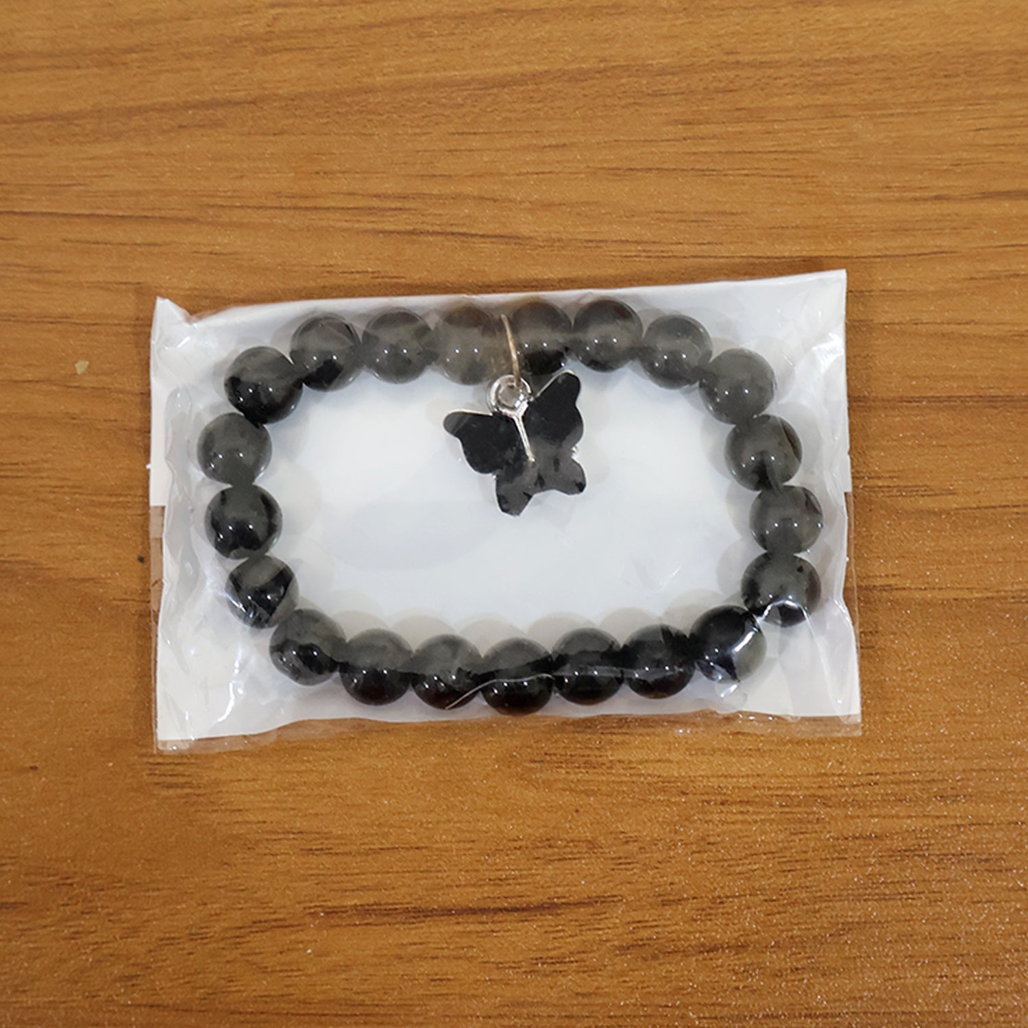 Styled display of beaded bracelet with elegant butterfly charm