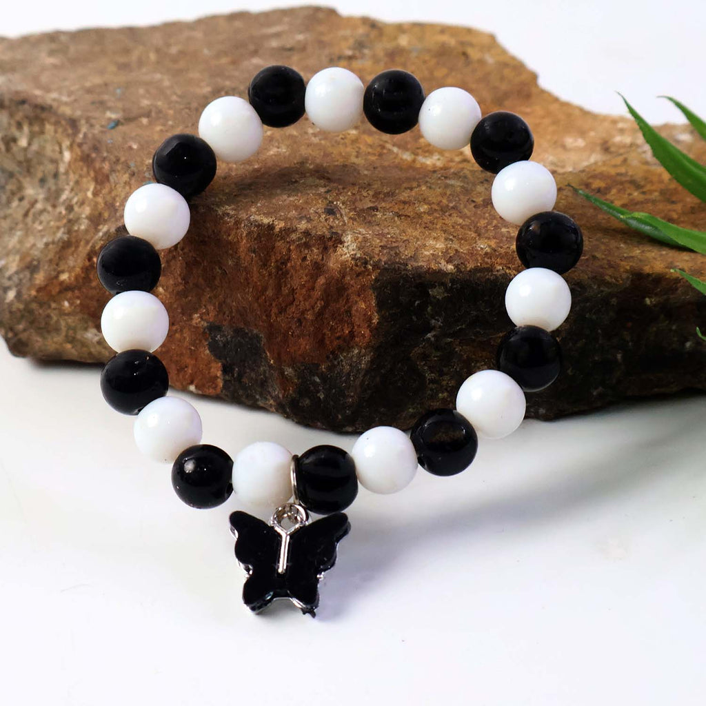 Designer black and white bracelet featuring cross charm