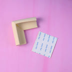 Close-up view of a furniture corner covered by a soft foam corner protector