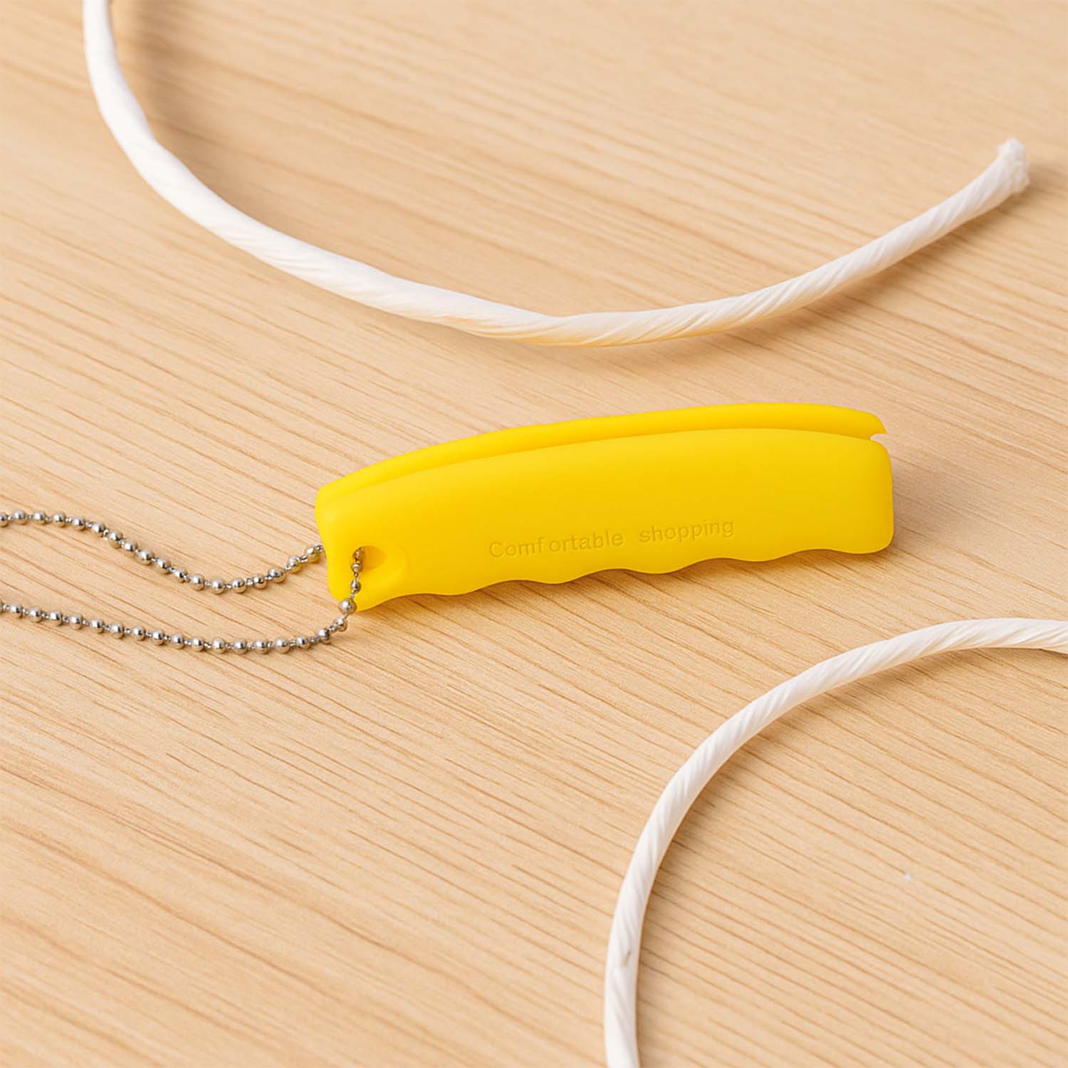 Close-up of the ergonomic, pea-shaped silicone grip on the bag carrier, highlighting comfort.