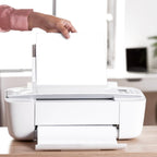 Stack of A4 copier paper next to a laser printer for office use