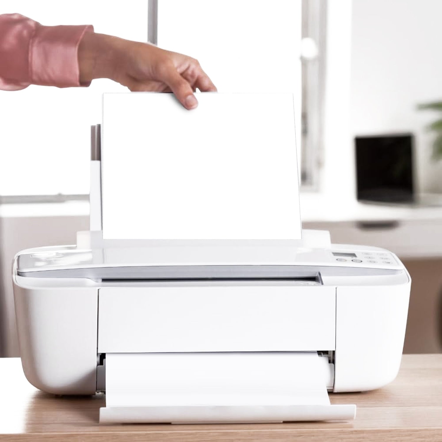 Stack of A4 copier paper next to a laser printer for office use