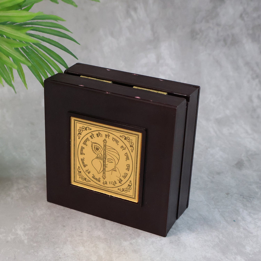 Top view of golden Charan Paduka with embossed metal art inside premium wooden case